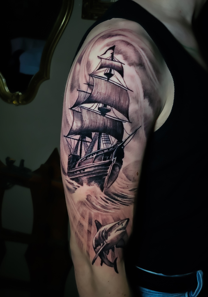 tatouage bras pirate, bateau pirate avec un requin